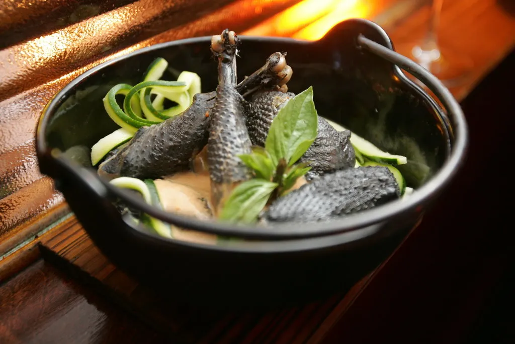 Poulet à peau noire cuit lentement dans une sauce au coco