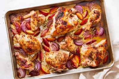 Poulet sur plaque avec prunes rôties et oignons